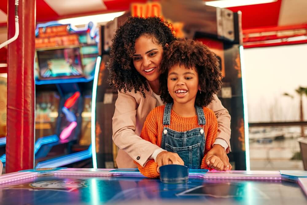 Parent and child playing at an arcade, indoor activities in Myrtle Beach